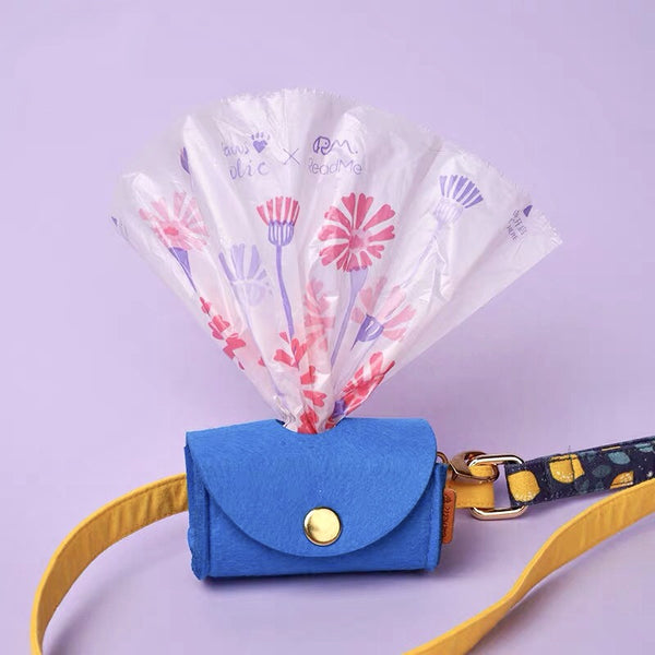 Sweep Dog Poop Bags floral print bags fanned from a blue felt dispenser pouch on a leash strap